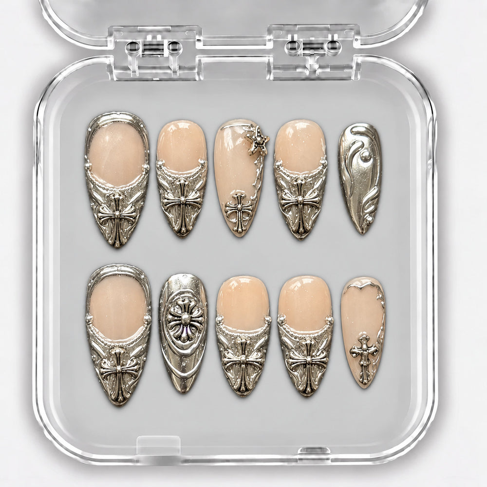 Set de dix press-on nails nude et argent, forme amande, avec ornements métalliques dans leur boîte.