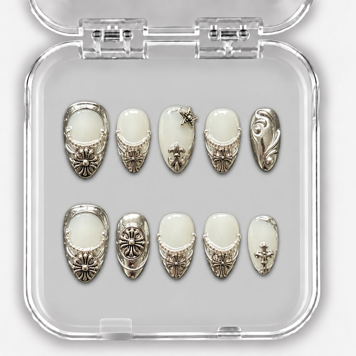 Set de dix press-on nails courts blanc laiteux et argent, avec ornements métalliques dans leur boîte.