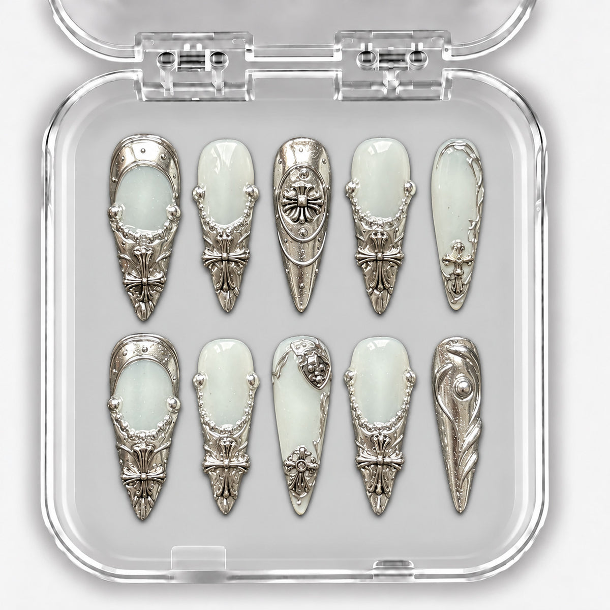 Set de dix press-on nails longs blanc laiteux et argent, avec ornements métalliques dans leur boîte.
