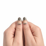 Nude & Argent — Court : press-on nails portés, détail des pouces, ornements argentés sur fond blanc.