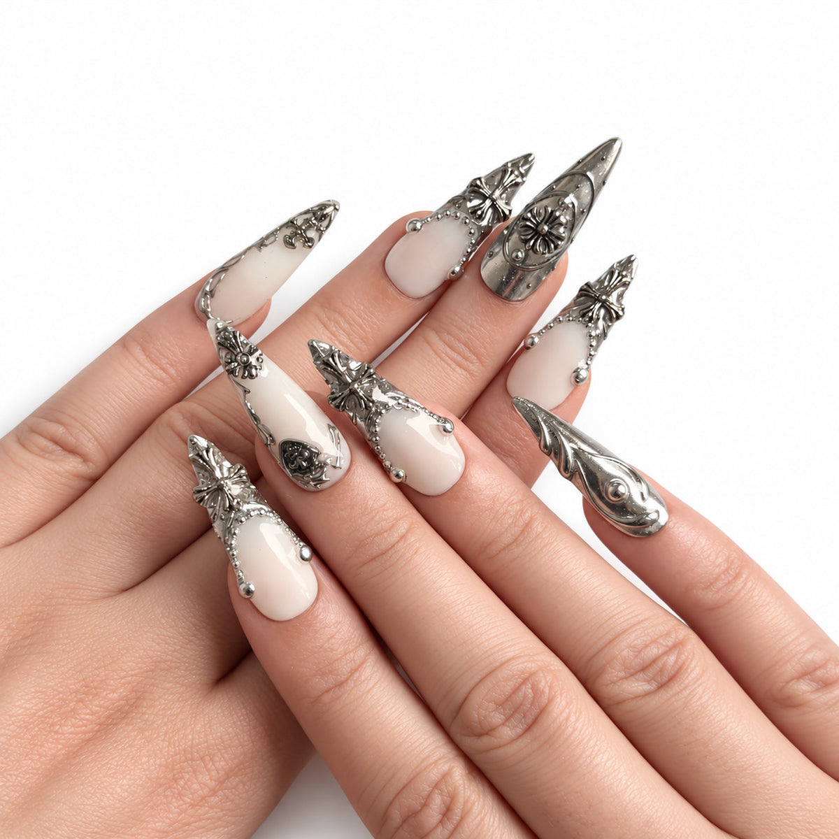 Blanc & Argent — Long : press-on nails portés, vue des mains, ornements argentés sur fond blanc.
