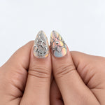 CELESTIAL LOVE — Press-on nails NELI portés, gros plan des deux pouces.
