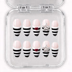 La Rebelle – Press-On Nails French rayée noire et blanche à bouche rouge et étoiles argentées, longueur moyenne forme amande