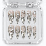 LIQUID SILVER LONG — Unghie press-on, stiletto, lunghe. Nude, arabeschi argentati e punte cromate.