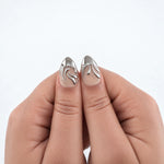 LIQUID SILVER MINI — Press-on nails NELI portés, gros plan des deux pouces.