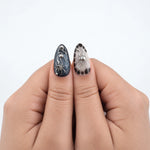 SILVER PHANTOM — Press-on nails NELI portés, gros plan des deux pouces.