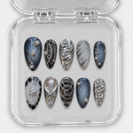 SILVER PHANTOM — 10 uñas press-on, Almendra, medias. Azul noche, marmolado negro y cromo.